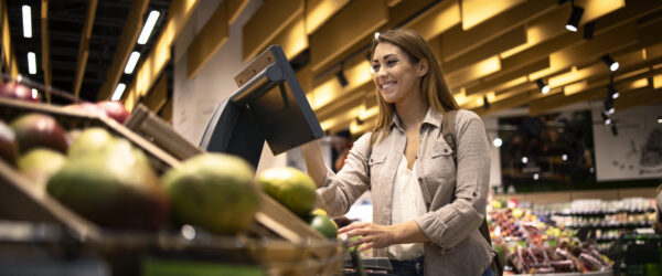 Mulher no supermercado usando balança digital